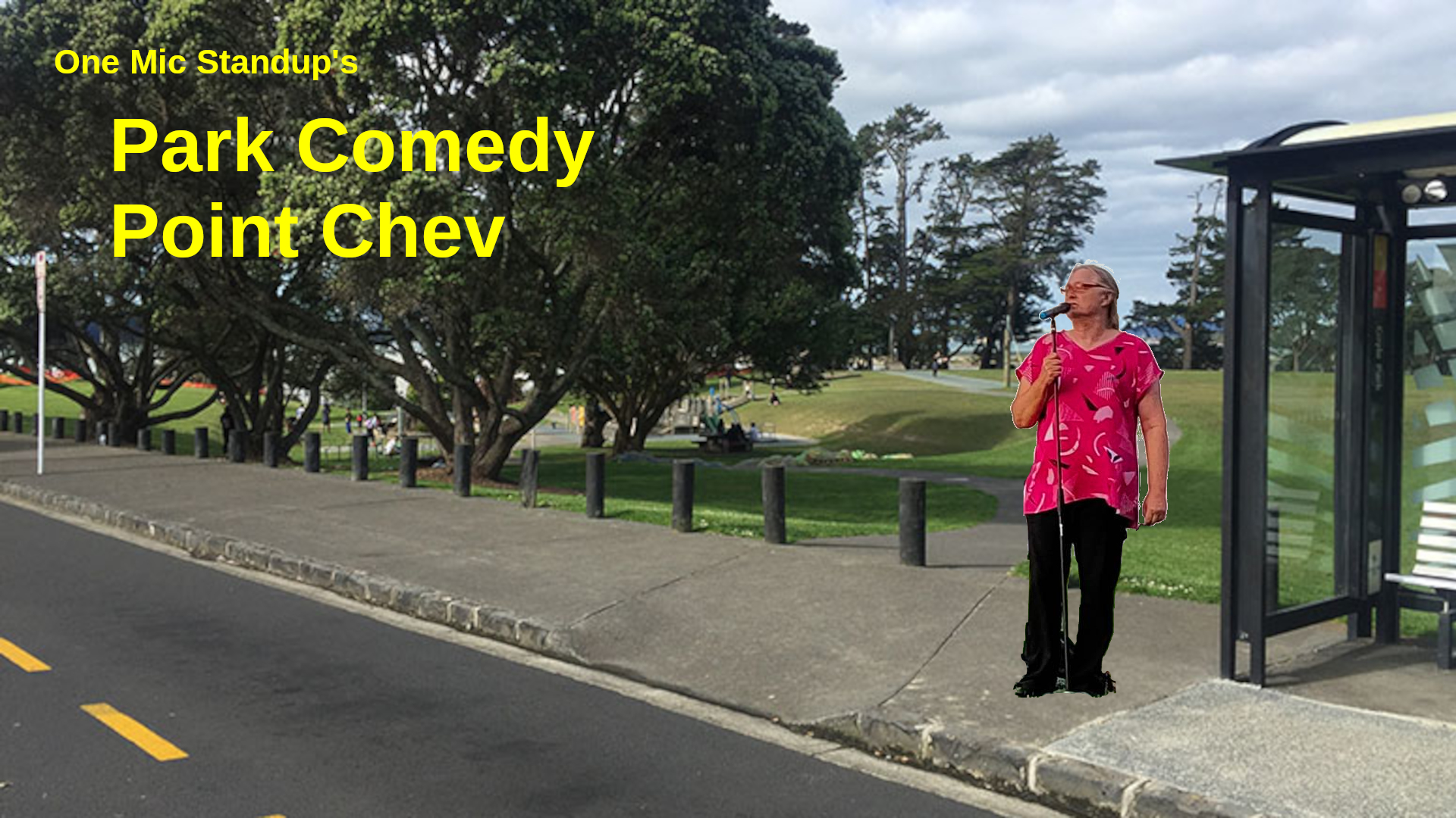 A comedian with microphone stands on the footpath by a large park